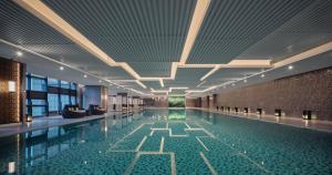 昆山Holiday Inn & Suites Kunshan Huaqiao, an IHG Hotel - F1 Racing Preferred Hotel的一座带天花板的大型游泳池