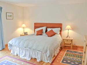 MilfieldTill Cottage的一间卧室配有一张带2个床头柜的大床