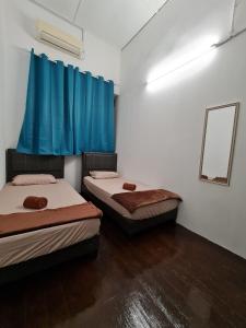 乔治市Amilite Heritage Villa的配有蓝色窗帘的客房内的两张床