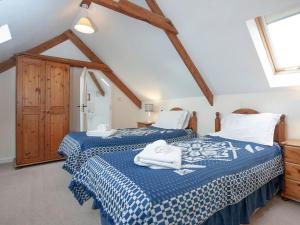 Crackington Haven圆屋乡村别墅的一间卧室配有两张带毛巾的床