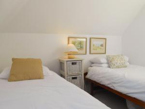 帕兹托贝拉吉欧乡村别墅的一间卧室设有两张床和一张桌子上的台灯。