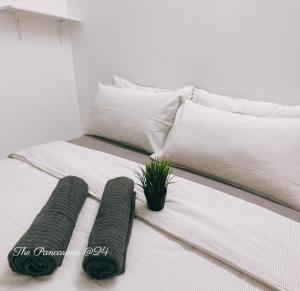 怡保The Pancarona24 Homestay forMuslim的床上有2个枕头,上面有盆栽植物