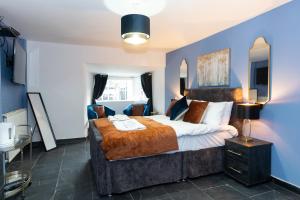 巴纳德城堡古代独角兽宾馆的一间卧室设有一张大床和蓝色的墙壁
