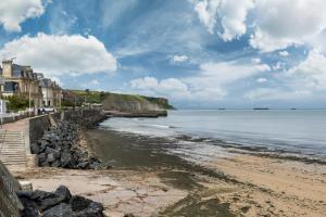 阿罗芒什莱班Les volets bleus - duplex proche plage et centre的享有海滩美景,设有房屋和大海