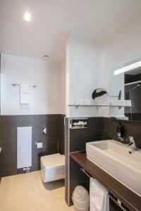 谢布尔普利尔皮纳酒店的浴室配有白色水槽和卫生间。