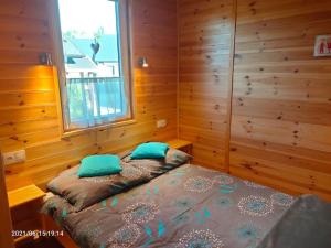 鲁斯诺沃Wakacyjne Zacisze的一间卧室配有一张带蓝色枕头的床和一扇窗户。