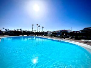 马斯帕洛马斯Escarabajo Bungalow il Maggiolino的一个大型蓝色游泳池,背面是阳光