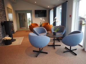 Hotell Skolestua的一间设有椅子和桌子的等候室和一间房间