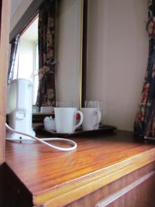 都柏林奥多诺霍德酒店的一个带两个杯子的柜台和一个吹风机