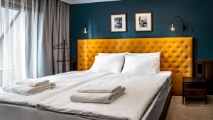 佩奇Palatinus Boutique Hotel的一间卧室配有一张大床和两条毛巾