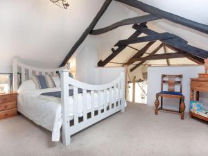 Crackington Haven安奈克思酒店的卧室配有白色的床和婴儿床。