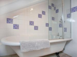 Crackington Haven安奈克思酒店的白色的浴室设有浴缸和玻璃淋浴间。