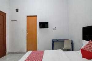 杜迈OYO 92111 Dinda Homestay Syariah的卧室配有床、桌子和门
