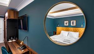 佩奇Palatinus Boutique Hotel的一间蓝色墙壁上带镜子的卧室