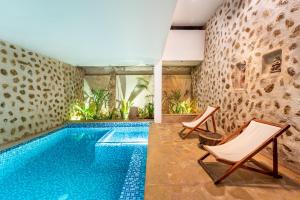 蓬蒂切里Conch Resort Luxury Private Pool Suites的别墅内的游泳池配有两把椅子