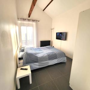 奥尔日河畔于维西Residence du Parc des Grottes - N 3的卧室配有一张床,墙上配有电视。