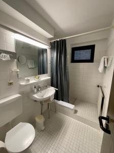巴特瑙海姆不论恩霍夫酒店的白色的浴室设有水槽和卫生间。