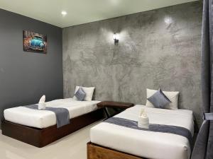 Thung SongNao Ta Chuang的一间卧室设有两张床和混凝土墙