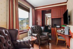松达尔兰格西佳酒店的一间设有皮椅、桌子和窗户的房间