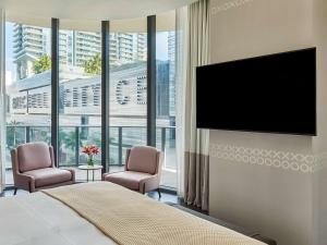 迈阿密布里克尔SLS勒克斯酒店的一间卧室设有平面电视和两把椅子