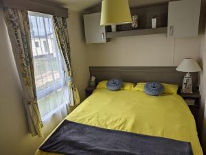 赫彻姆Beachhome的一间卧室设有一张黄色的床和窗户