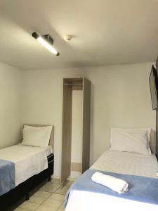 里奥韦尔迪HOTEL RIO VERDE的配有白色床单的客房内的两张床