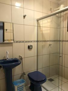 里奥韦尔迪HOTEL RIO VERDE的浴室设有蓝色卫生间和玻璃淋浴间。