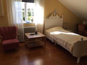 Hökerum秀布莱博斯度假屋的一间卧室配有一张床、一把椅子和一张桌子