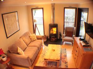 AymestreyThe Wooden Lodge的带沙发和壁炉的客厅