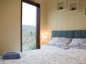 AymestreyThe Wooden Lodge的一间卧室设有一张床和一个大窗户