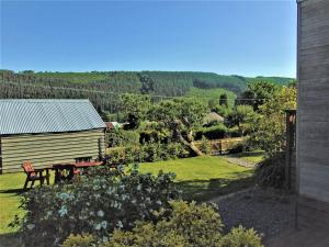 AymestreyThe Wooden Lodge的享有带长凳和房屋的花园美景。