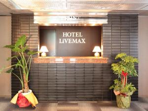 调布市HOTEL LiVEMAX BUDGET Chofu-Ekimae的酒店大堂墙上挂有植物