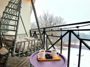 NikortsmindaCottage in Racha Mero的阳台上桌上的两杯咖啡