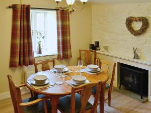 AuchnastankWoodside Cottage的一间带桌椅和壁炉的用餐室