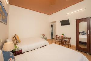 会安草莓园民宿的酒店客房设有两张床和一张桌子。