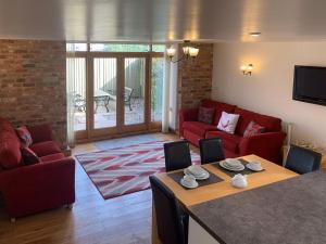 North Somercotes格兰纳里度假屋的客厅配有红色的沙发和桌子