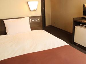 调布市HOTEL LiVEMAX BUDGET Chofu-Ekimae的酒店客房,配有床和电视