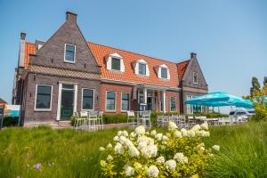 厄伊特丹Comfort Rooms & Appartments by EuroParcs Poort van Amsterdam的房屋前面有椅子和遮阳伞