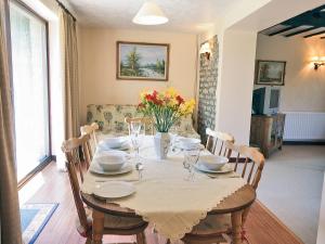 奇平索德伯里Fox Cottage - E4510的餐桌,配有白色桌布和鲜花