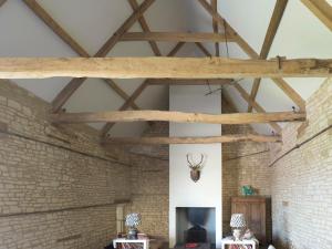 Ampney CrucisThe Cotswold Barn的一间设有砖墙和木梁的客房