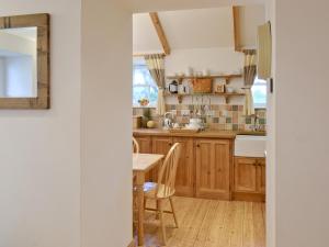 圣贾斯特Meadow Cottage的厨房配有木制橱柜和桌子