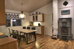SonkaVilla Mustikkakumpu的厨房以及带桌子和壁炉的用餐室。