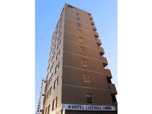 川崎HOTEL LiVEMAX BUDGET Kawasaki Ekimae的一座高大的棕色建筑,上面有标志