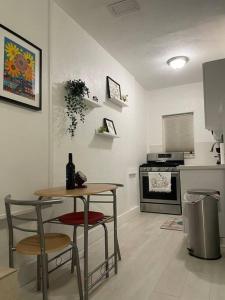 迈阿密Comfortable modern apartment- central location.的厨房配有桌子、两张凳子和一张带葡萄酒瓶的桌子。