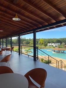 阿瓜斯-迪圣巴巴拉Vale Das Águas Fazenda Resort的一个带桌椅的庭院,享有游泳池的景色