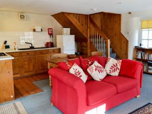Bardon Mill菲尔布里奇度假屋的客厅设有红色沙发,位于厨房内