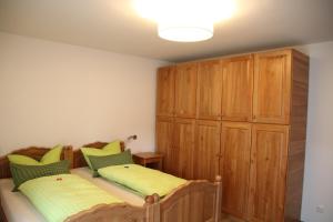 加尔米施-帕滕基兴Alpen - Apartments的一间卧室设有两张床和木制橱柜