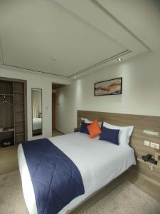 卡萨布兰卡LOTUS HOTEL Casanearshore的一间卧室配有一张带蓝色和橙色枕头的大床