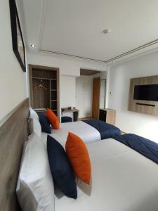 卡萨布兰卡LOTUS HOTEL Casanearshore的一间卧室配有两张带橙色和蓝色枕头的床