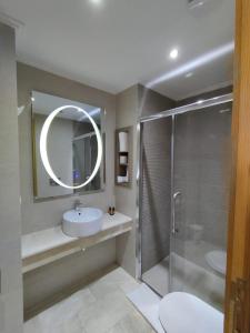 卡萨布兰卡LOTUS HOTEL Casanearshore的浴室配有盥洗盆和带镜子的淋浴
